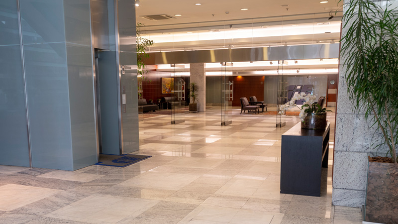 Foto da entrada do Foyer (Salão de Eventos), com um elevador à esquerda e o amplo espaço ao fundo