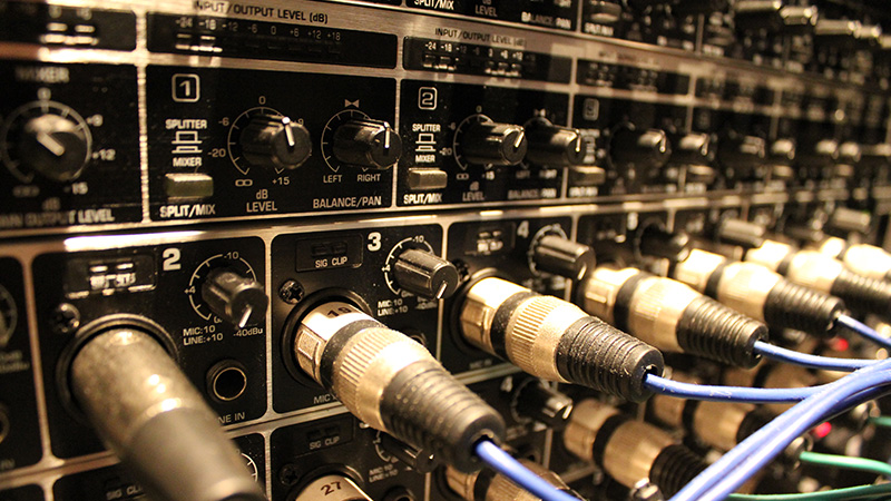 Foto de um equipamento de áudio com diversos cabos conectados