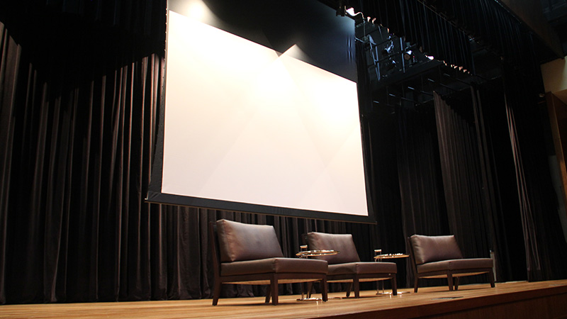Foto do palco do Teatro CIEE, onde é mostrado a tela de projeção 186″ no formato 16:10