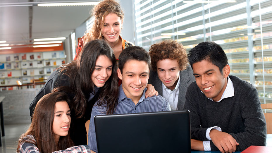 Grupo de seis jovens olhando para tela de um computador