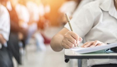 Estudante escrevendo numa sala de aula