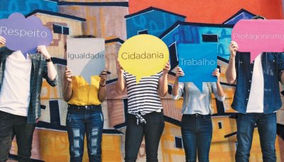 Cinco pessoas segurando balões de quadrinhos, em cada um está escrito Respeito, Igualdade, Cidadania, Trabalho e Protagonismo