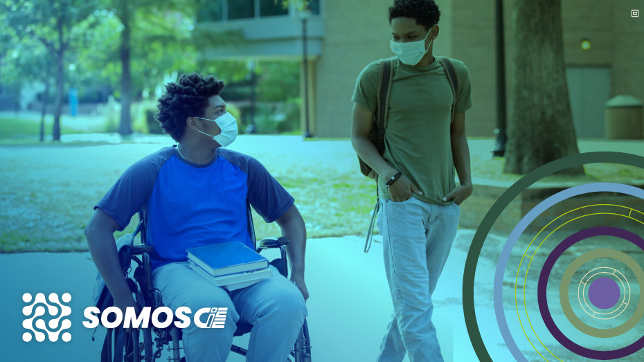 #PraCegoVer #ParaTodosVerem #DescriçãoDaImagem: Jovem estudante em cadeira de rodas junto com um colega em uma faculdade. Fim da descrição.